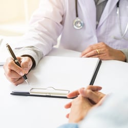 Doctor writing on a document